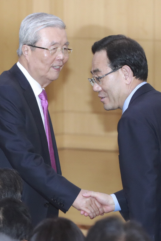 미래통합당 김종인(왼쪽) 비상대책위원장 내정자가 27일 국회에서 열린 전국조직위원장 회의에서 주호영 원내대표와 악수하고 있다.    연합뉴스